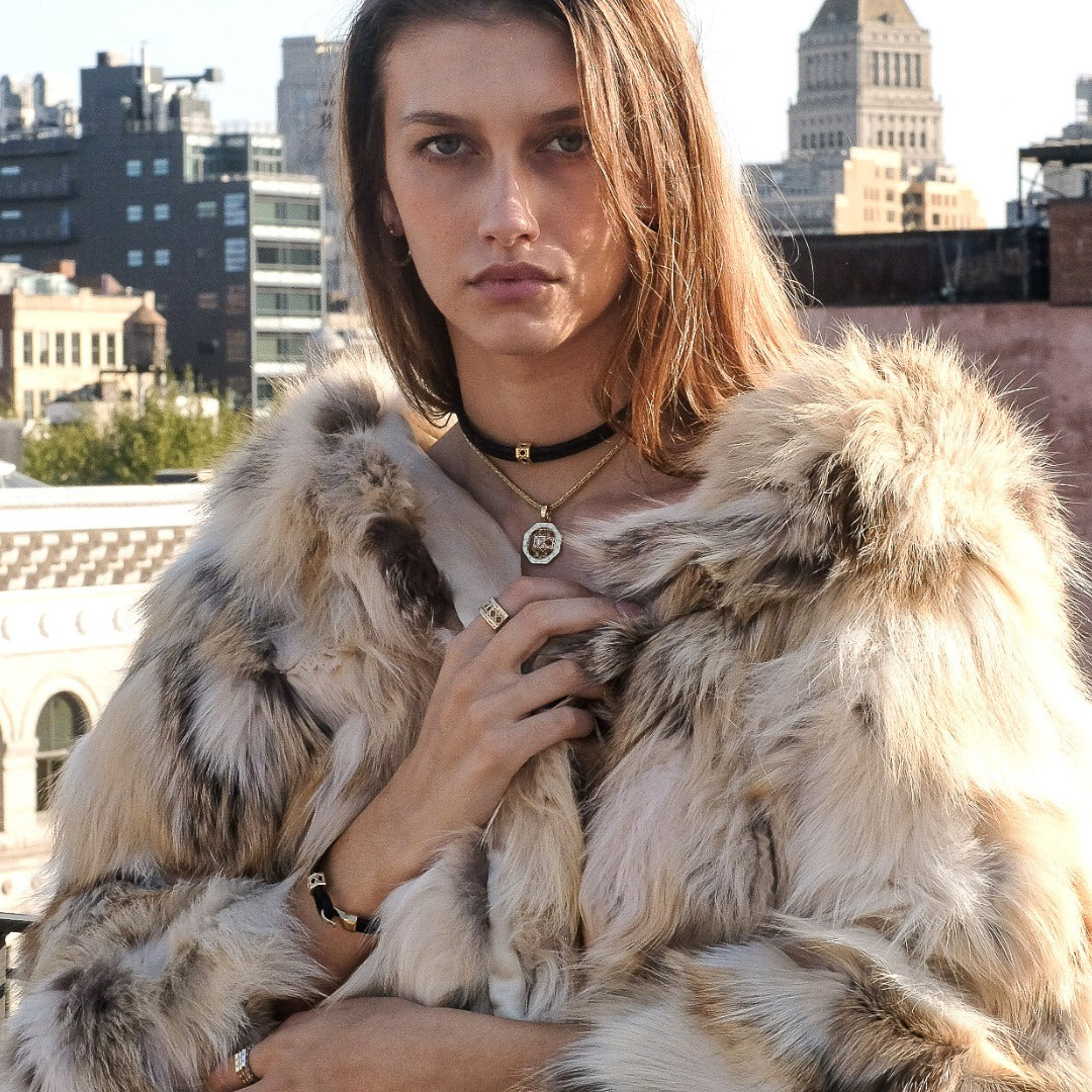 MoAnA LUU fine jewelry worn on model, featuring Abyss stingray leather choker and bracelet with gold and elements, paired with Doudou octagonal pendant necklace and rings in 18K yellow gold inspired by Caribbean fish traps.