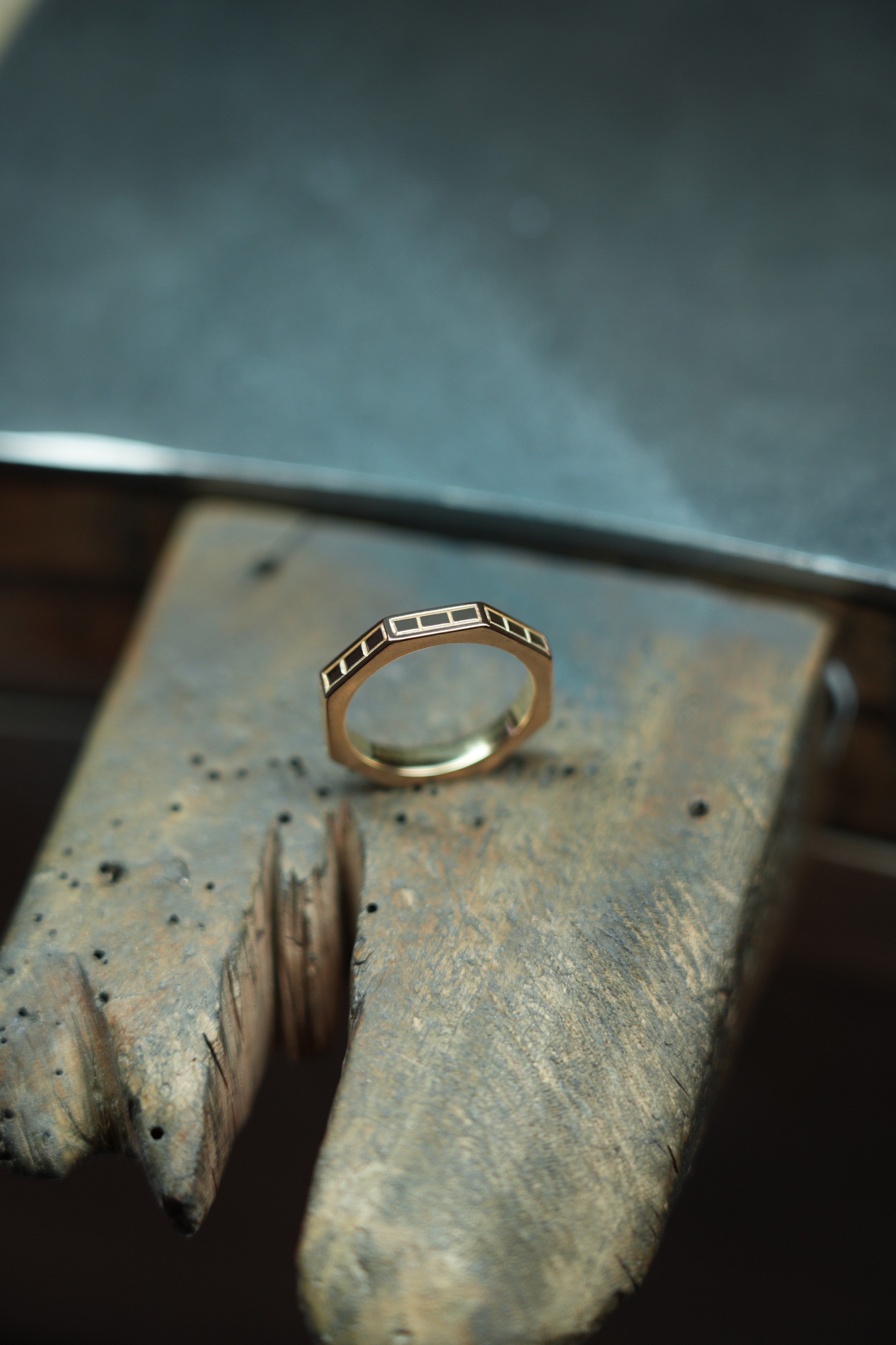 MoAnA LUU Ti ring in gold, featuring angular geometric design, displayed on a jeweler’s workbench.