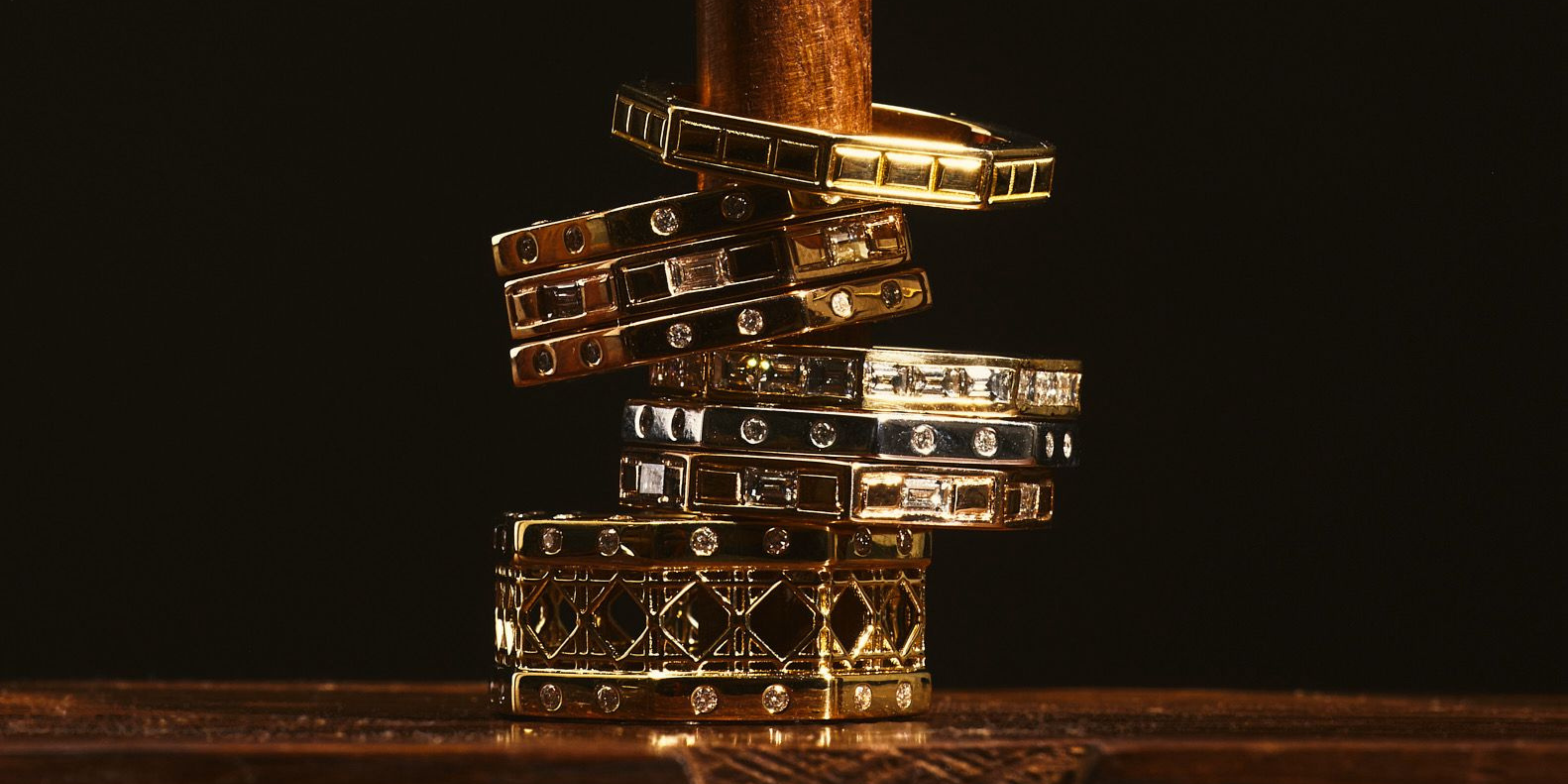 MoAnA LUU Ti rings stacked on wooden board.