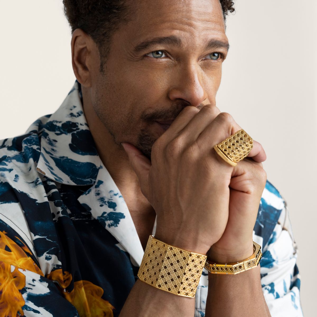 Gary Dourdan wearing MoAnA LUU Doudou maxi cuff, bracelet and maxi ring in 18K yellow gold, cane-woven work inspired by traditional Caribbean fish traps, reflecting the house’s vision of Creole-inspired fine jewelry crafted in New York.