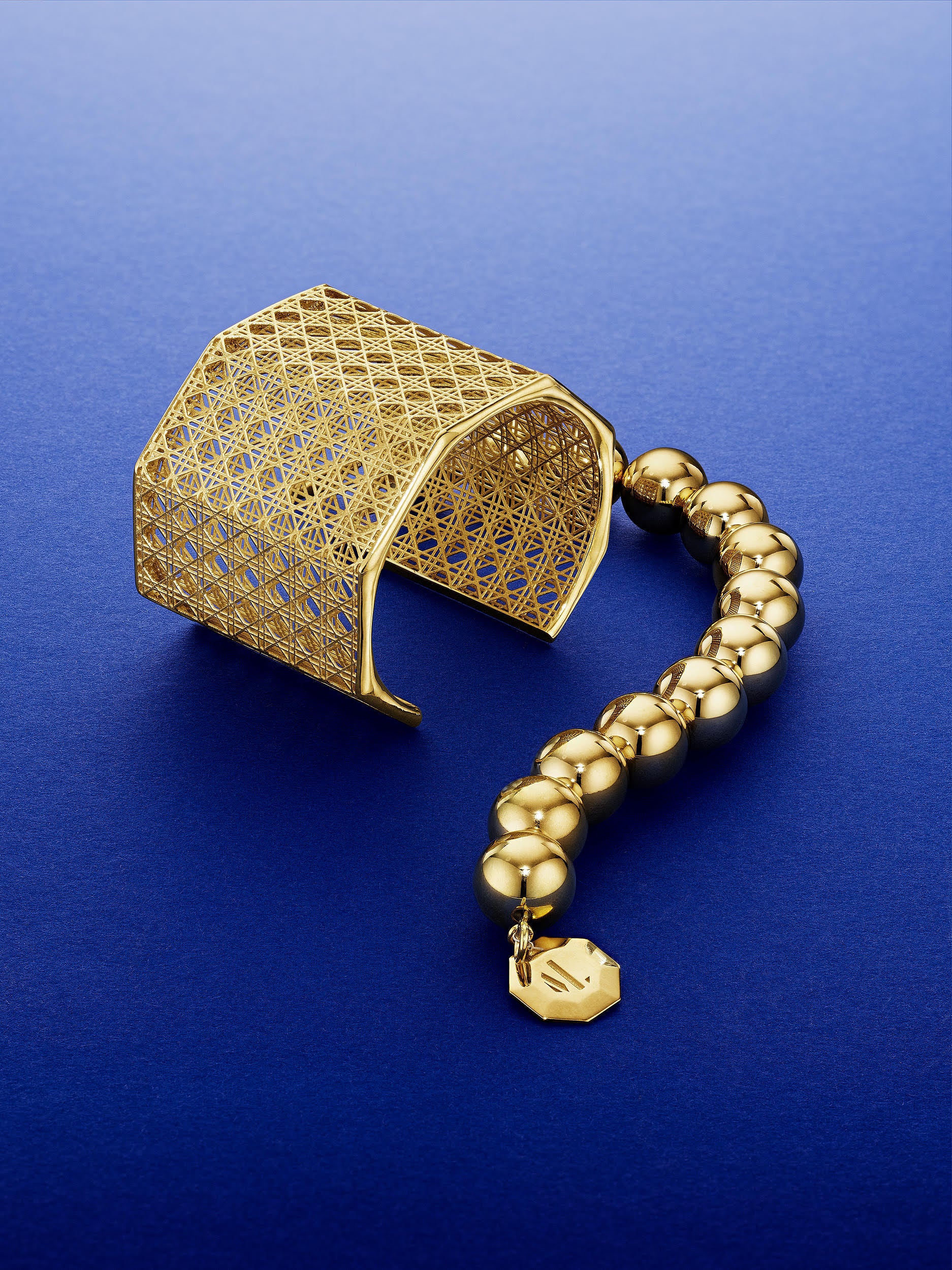 MoAnA LUU Beads bracelet and Doudou Maxi cuff bracelet in 18K yellow gold, featuring in intricate woven openwork design inspired by Caribbean fish traps.