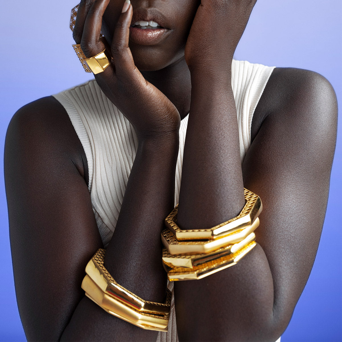 Model wearing MoAnA LUU Doudou bangle bracelets, paired with Doudou rings and earrings inspired by Caribbean fish traps.