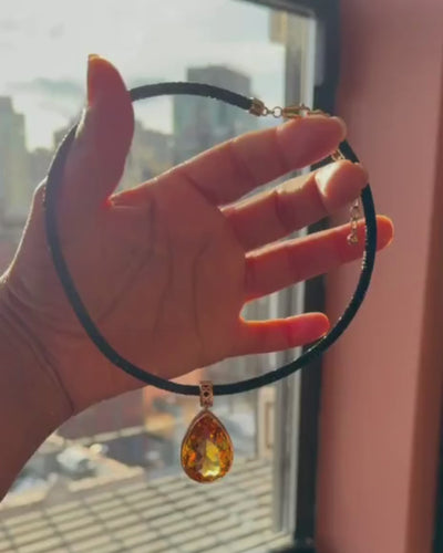 MoAnA LUU Maxi Dlo pear-shaped citrine pendant in 18K yellow gold held by hand, showcasing sculptural cane-woven design inspired by Caribbean fish traps.