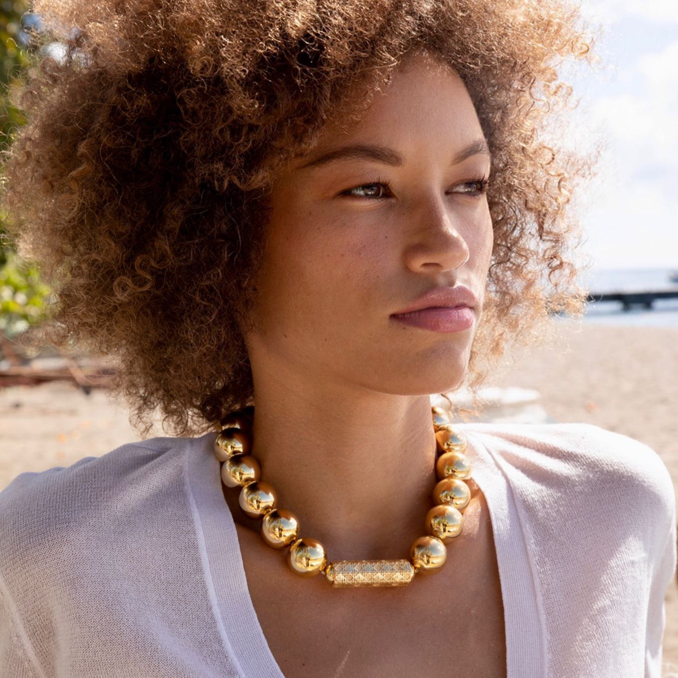 Model wearing MoAnA LUU Maxi Beads necklace with barrel lock in vermeil. 